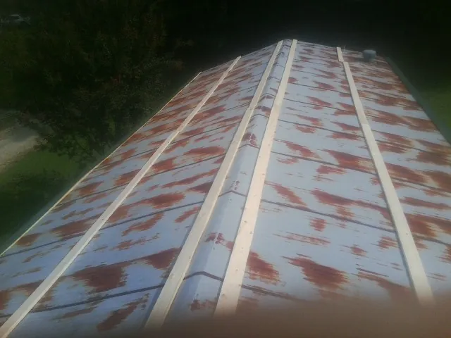 Rusted metal roof panels with new wood purlins before replacement — Storm Damage Roof Repair in Carteret by Roofing Brothers