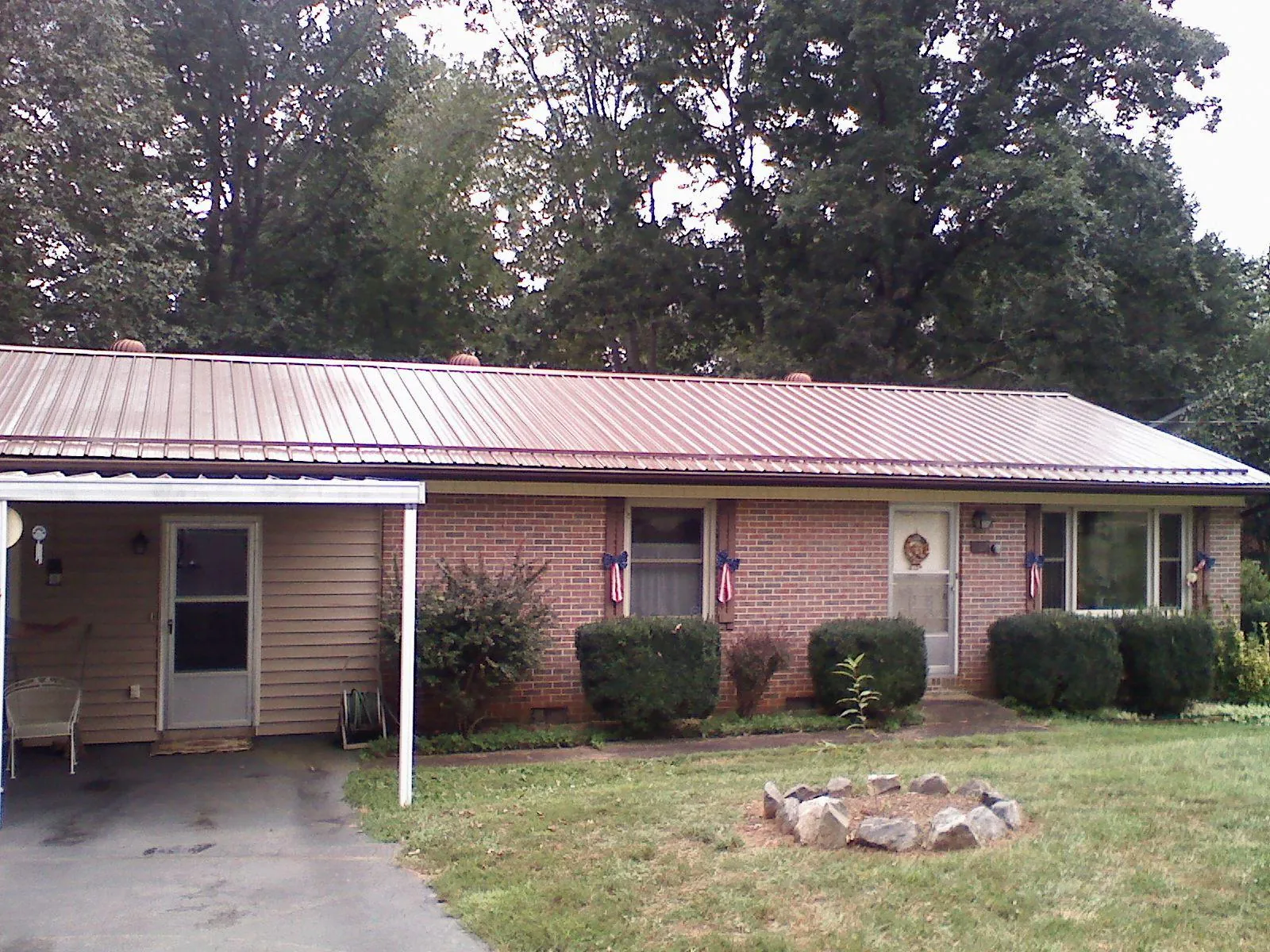 Bronze metal roof and carport on a brick ranch home — Roof Repair work by our crew in Carteret