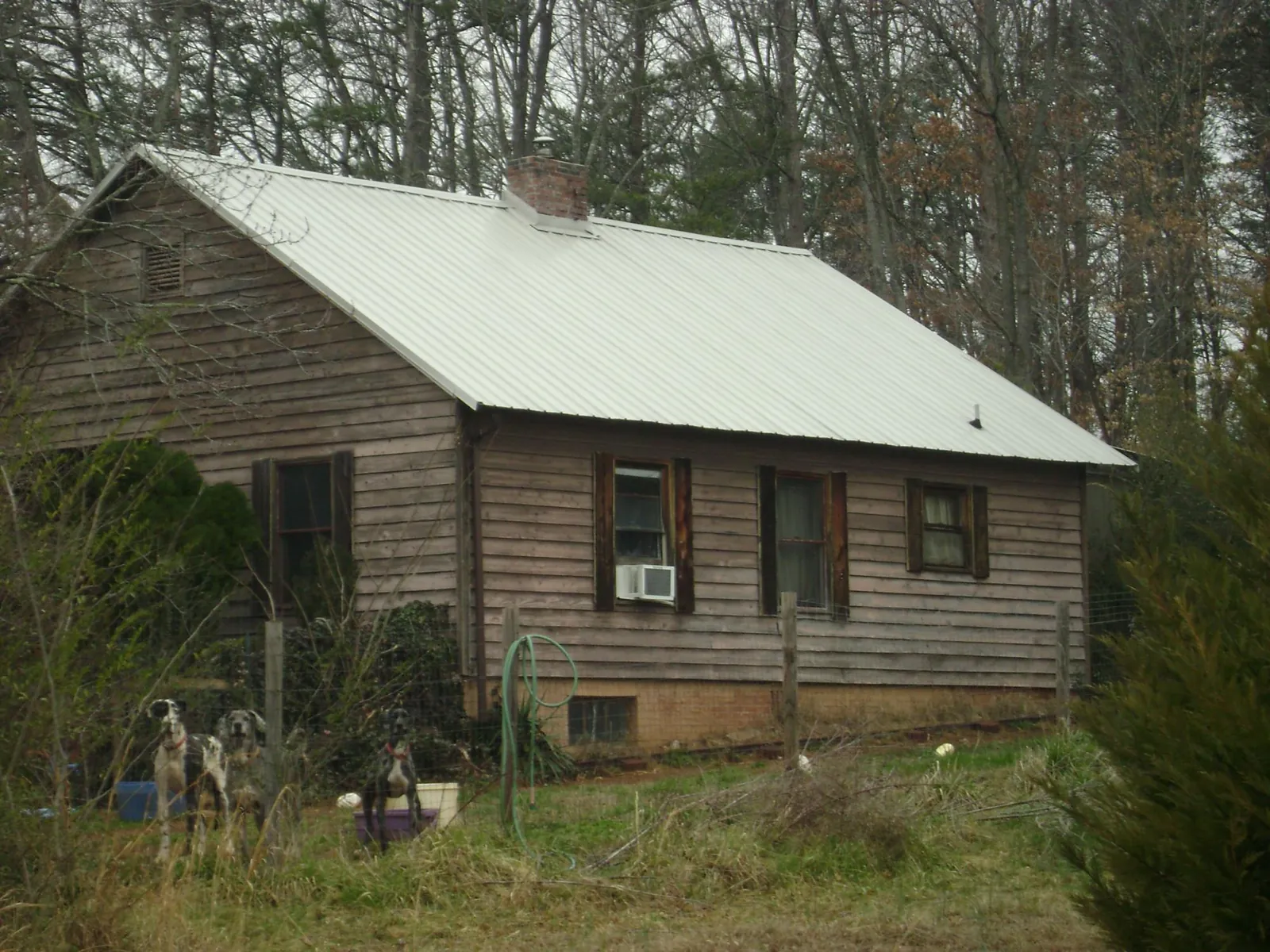White metal roof on an old wood sided farmhouse, from a Metal Roof Installation job in Carteret